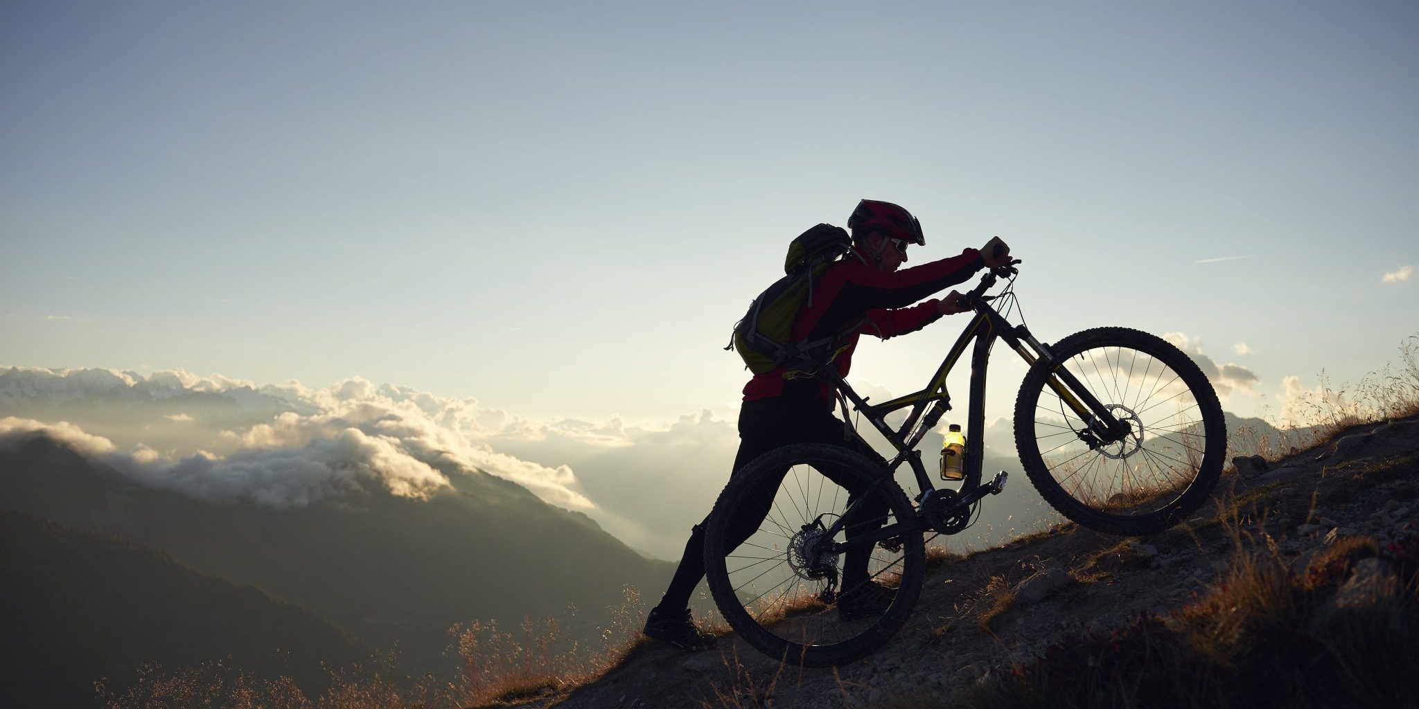 Mountain biker pushing bike uphill, Valais, Switzerland